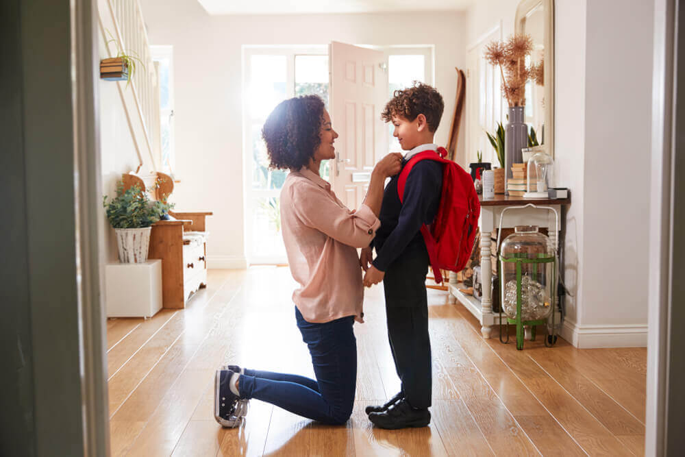 Madre preparando a su hijo para ir al cole.