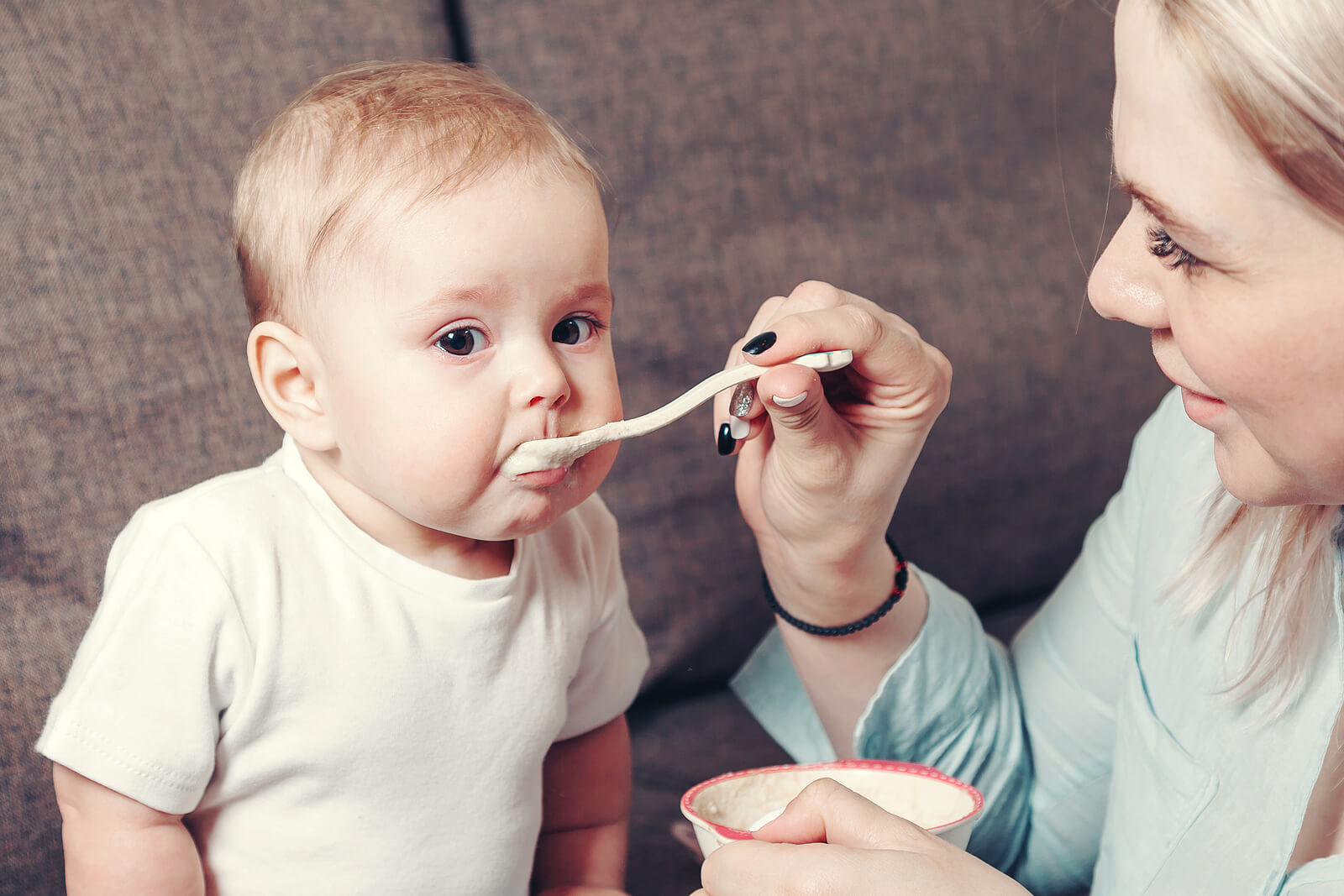 Madre dando de comer a su bebé.