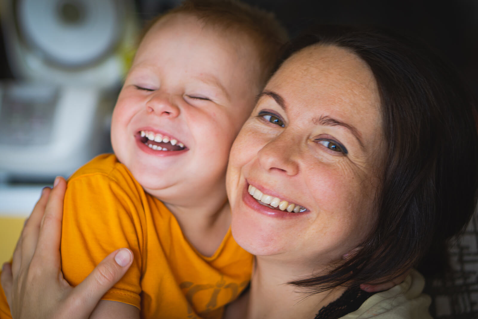 Mamá sonriendo junto a su hijo.