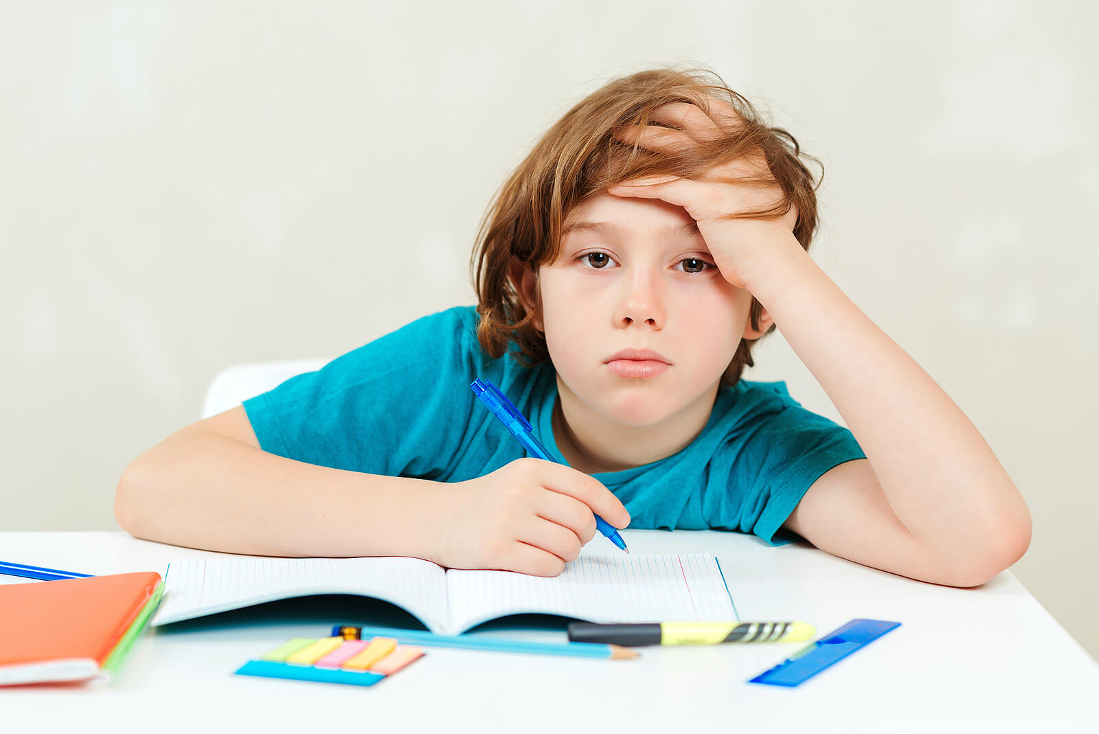 Niño aburrido porque sus padres no saben cómo motivar a los niños a hacer los deberes.