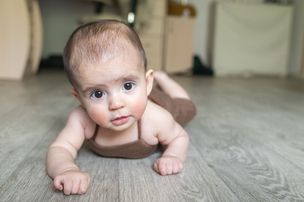 Niño en el suelo aprendiendo a gatear.