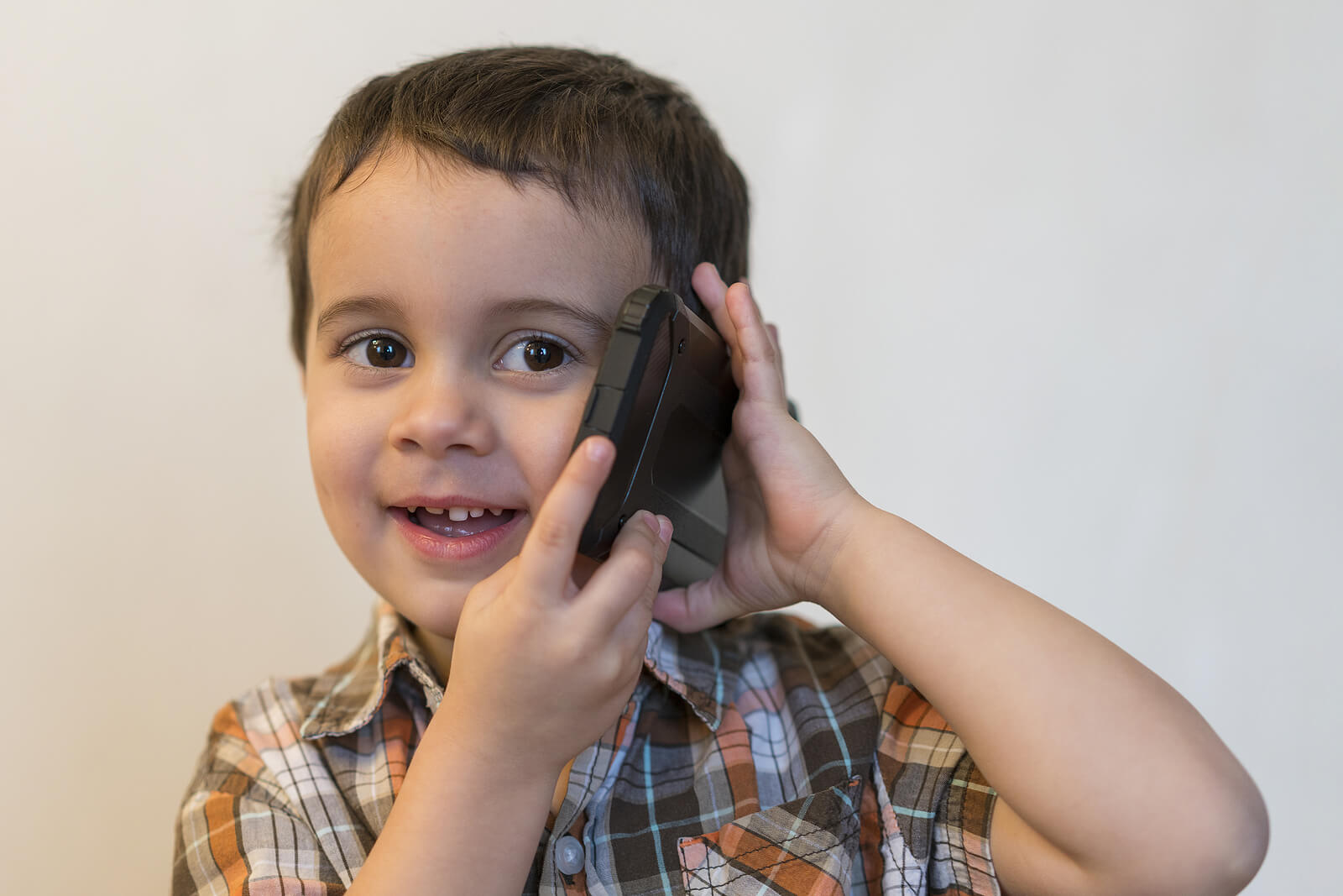 Garçon de trois ans parlant au téléphone.