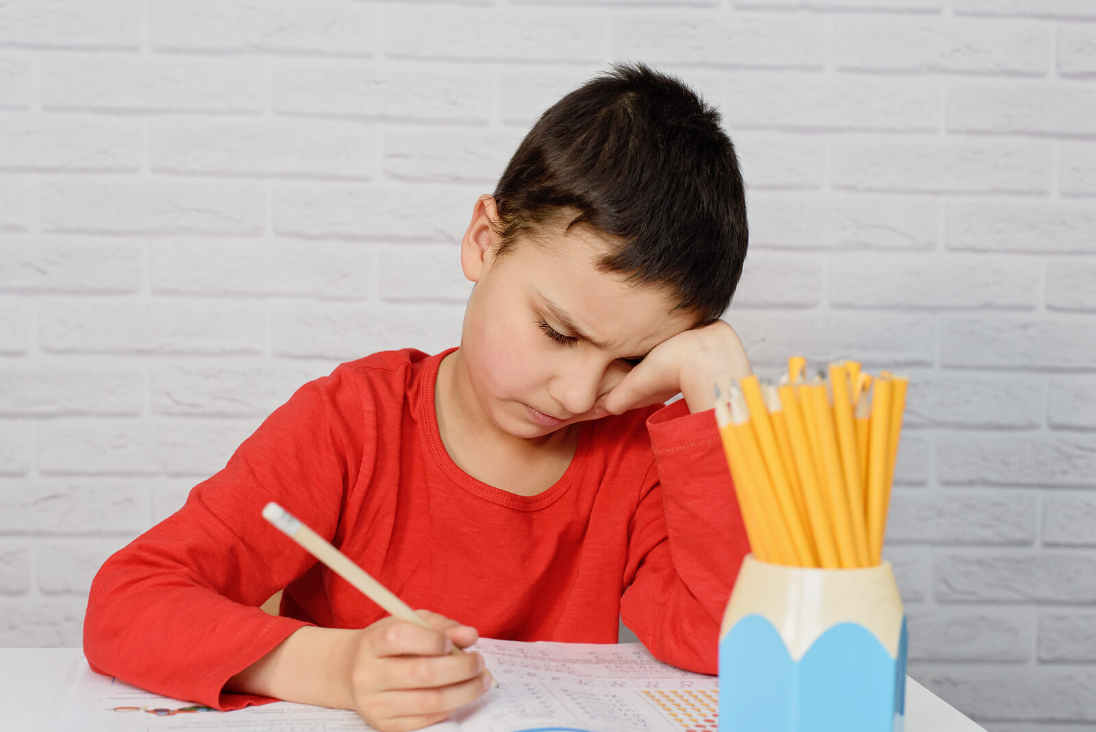 Niño intentando ponerse a estudiar.