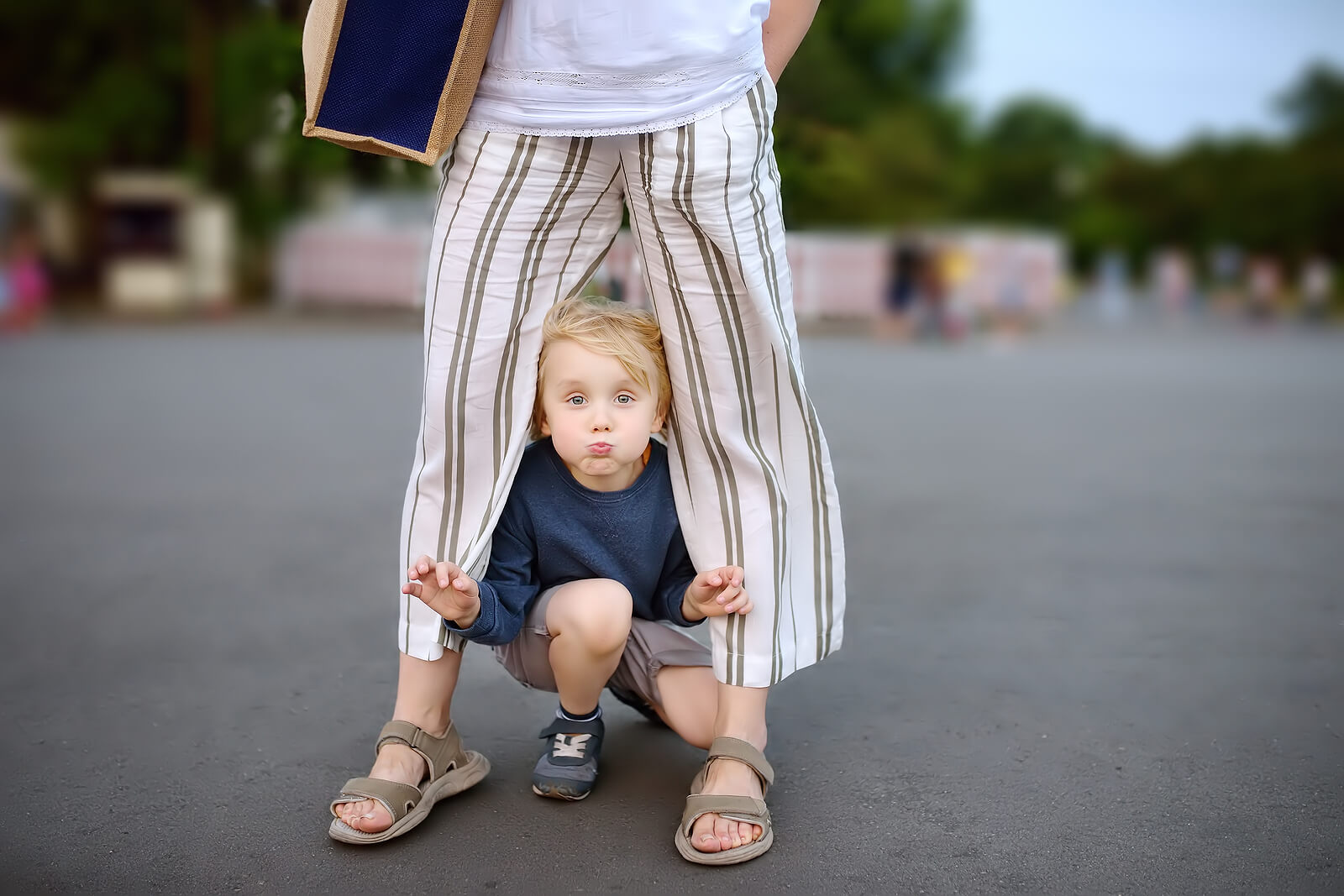 Niño jugando entre las piernas de su madre aplicando la obediencia según Montessori.