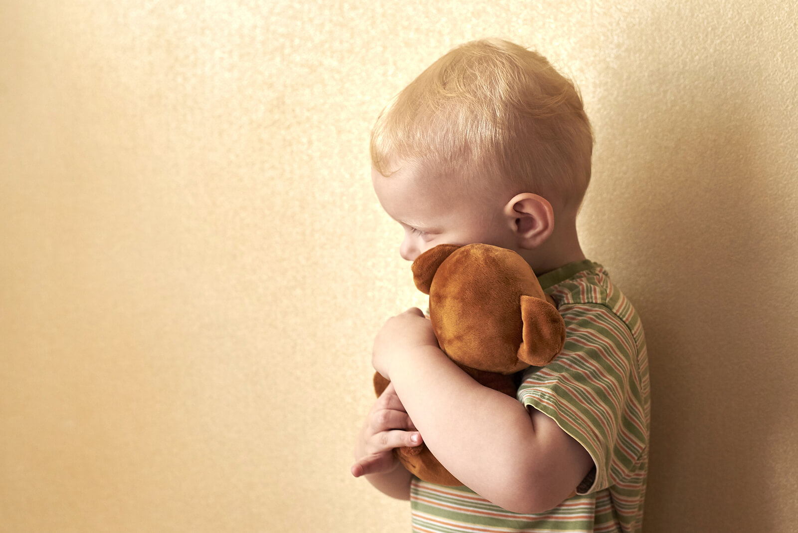 Niño abrazando un peluche porque tiene miedo a la muerte.