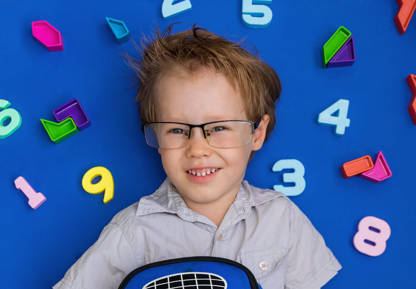 A child surrounded by math magnets.