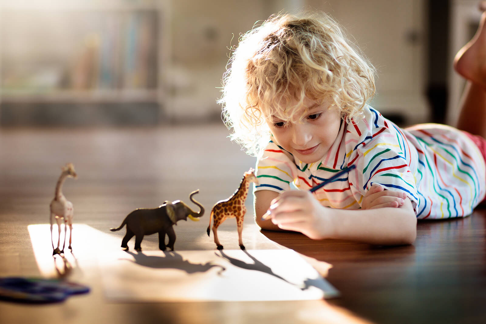 Niño dibujando animales.