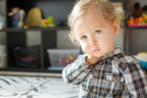 Niño pensativo y triste en su habitación.