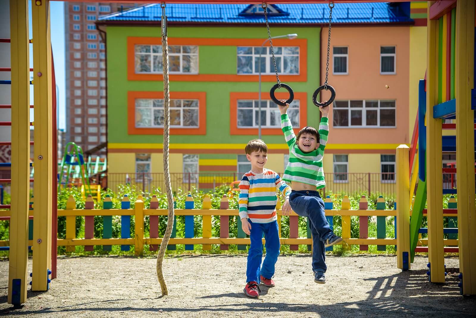 Niños jugando en los columpios cultivando el valor de la amistad.