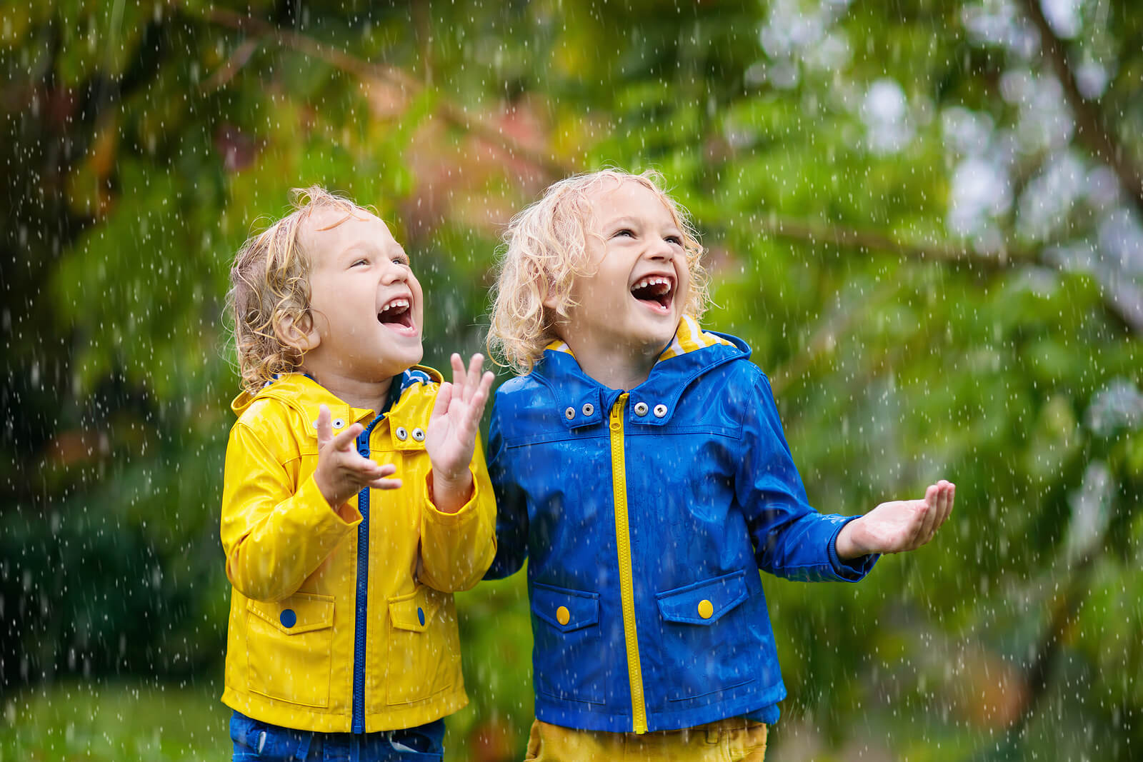 Niños disfrutando bajo la lluvia, un olor que impregnará sus recuerdos.