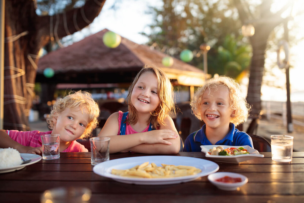 Niños comiendo en un restaurante durante las vacaciones.