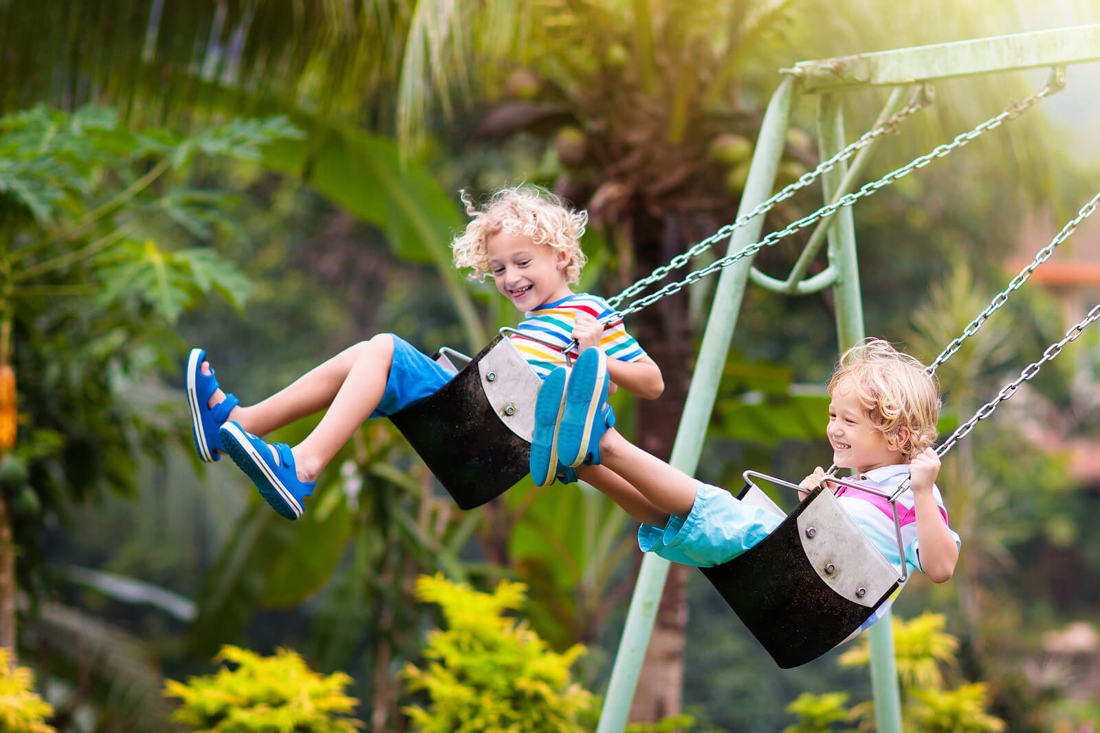 Niño jugando en los columpios del parque infantil.