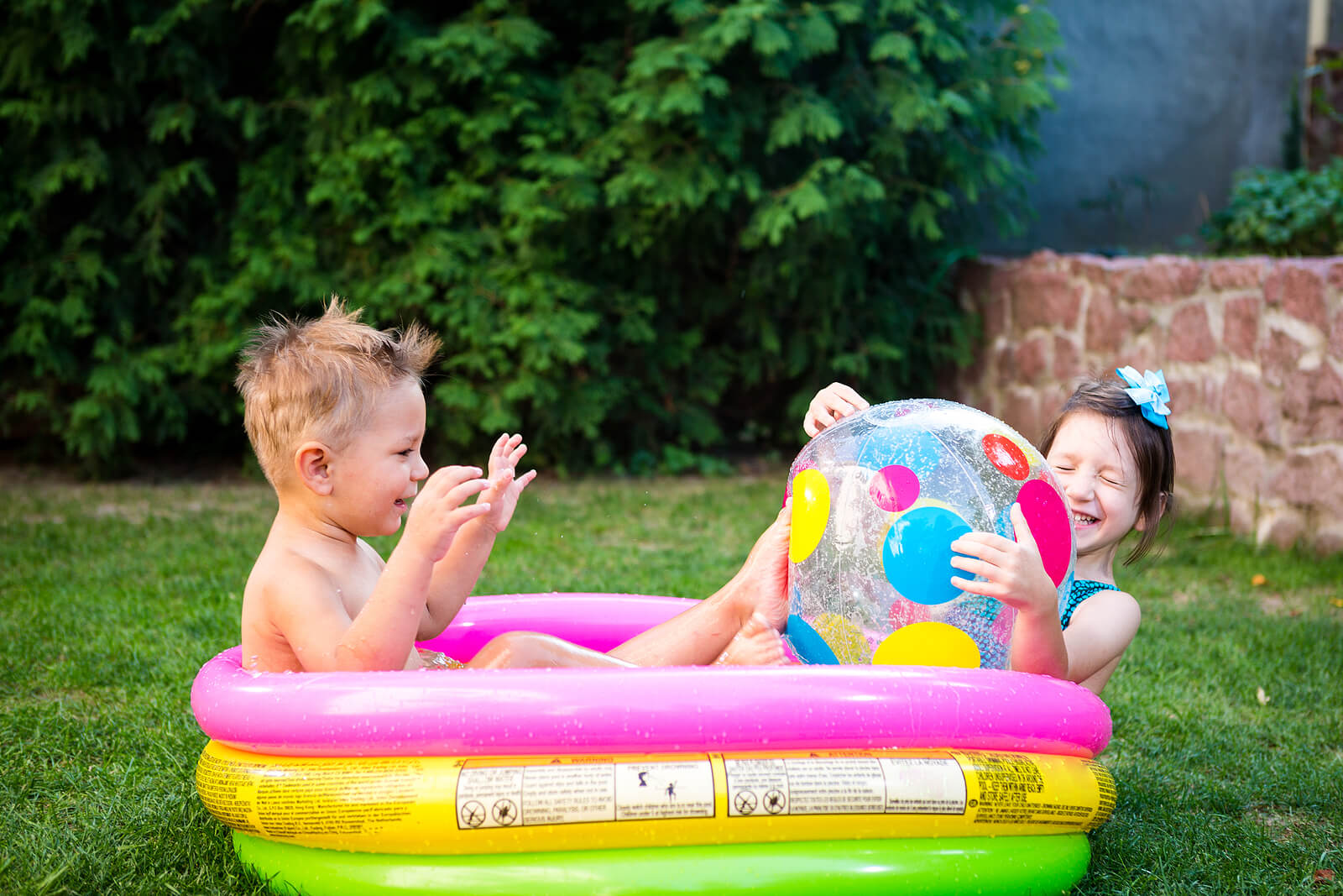 Niño jugando en una piscina hinchable en verano.