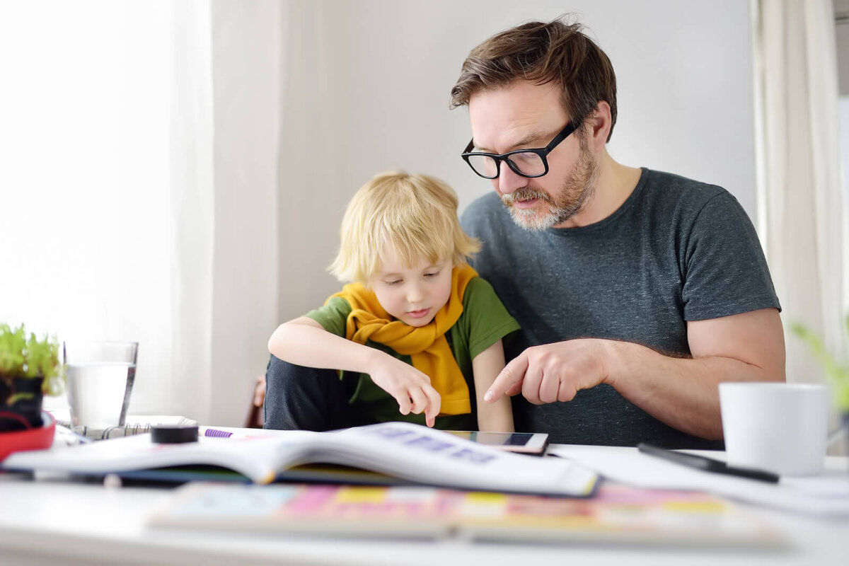 Padre ayudando con la tarea a su hijo.