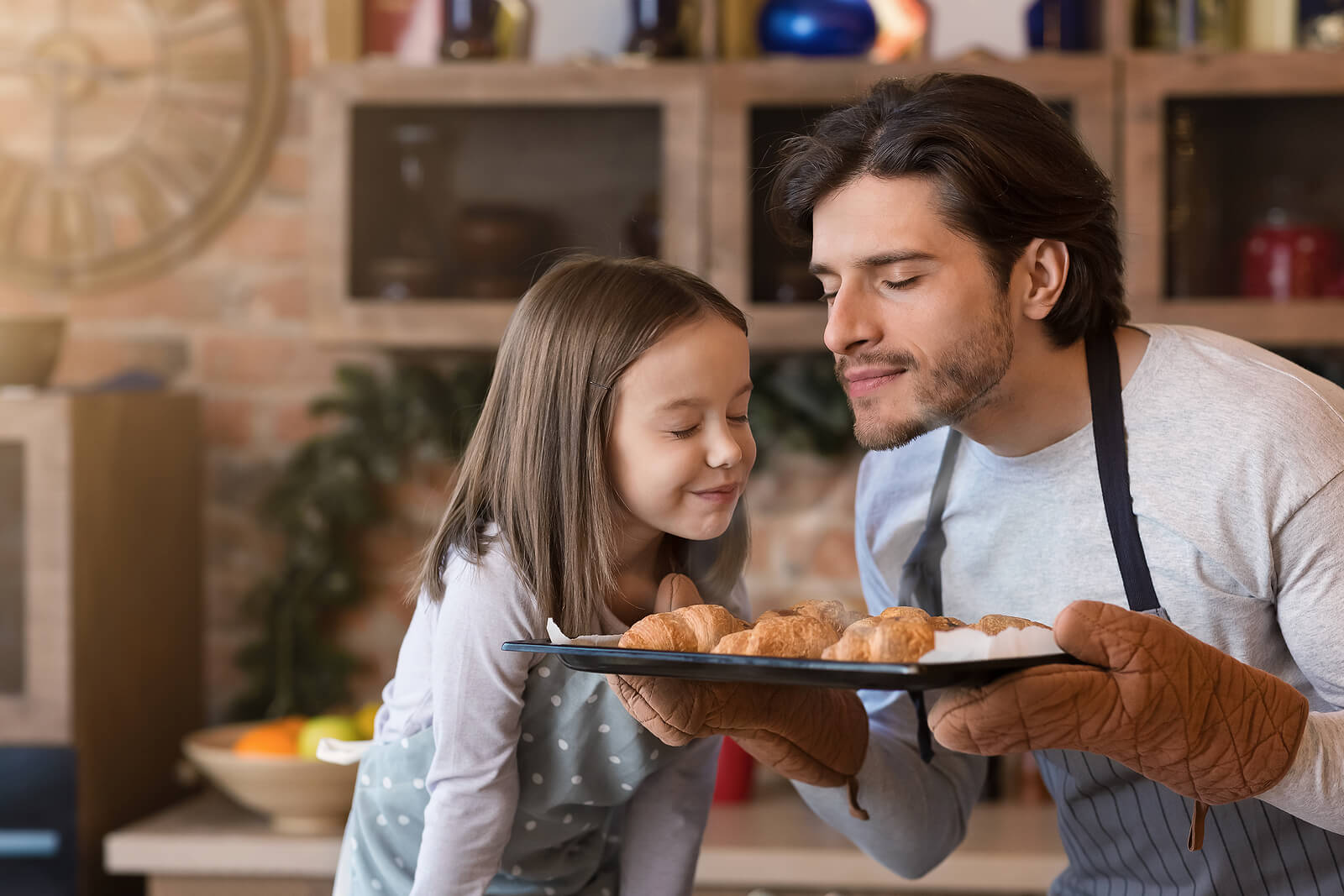 Padre e hija haciendo cruasanes al horno para llenar de olor su recuerdo.