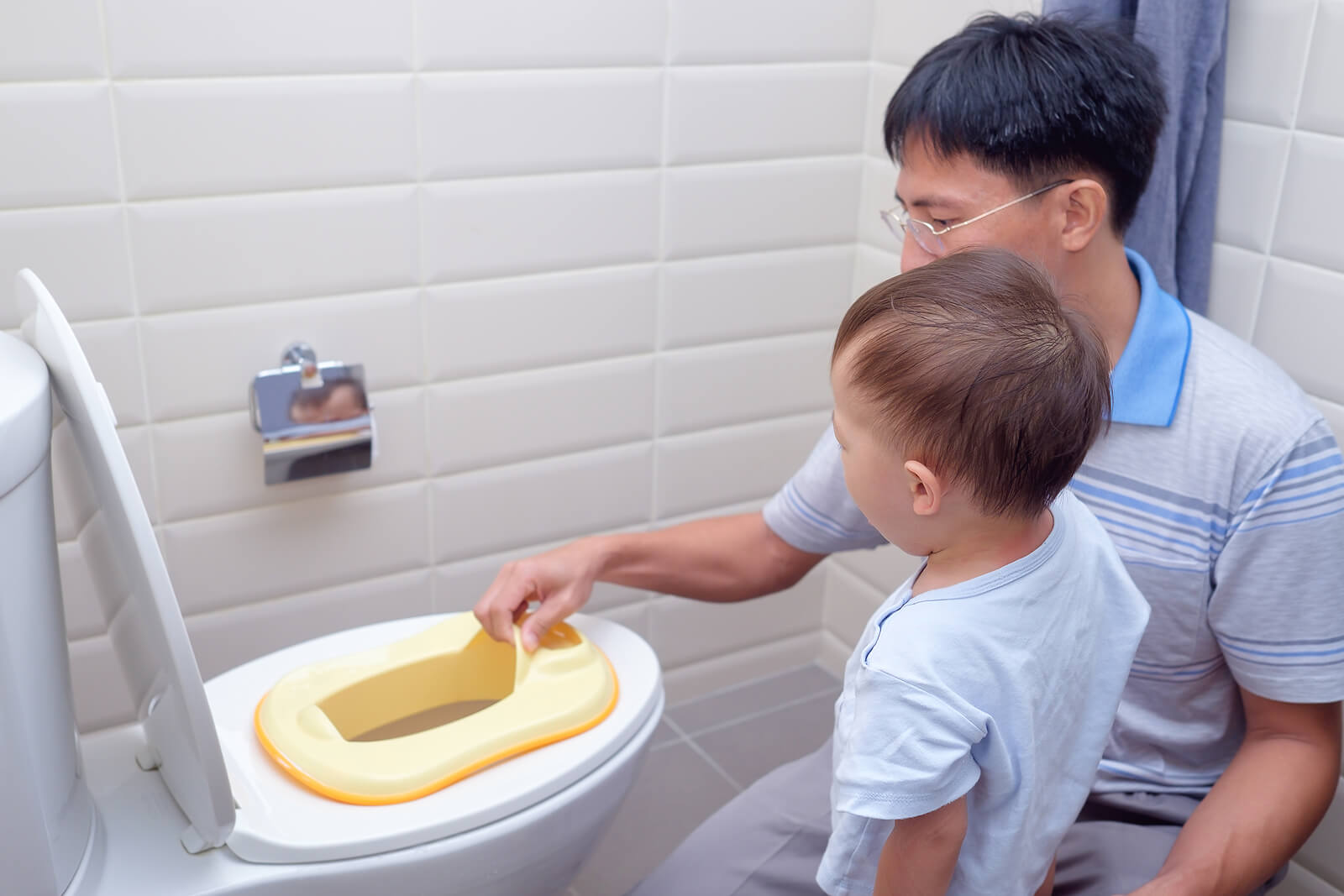 Padre enseñando a su hijo a usar el baño, porque un padre no es una niñera.