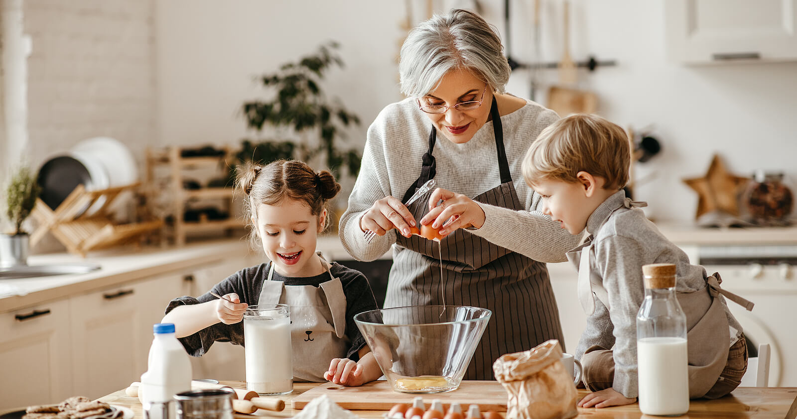 A grandma baking with her granddaughter and grandson.