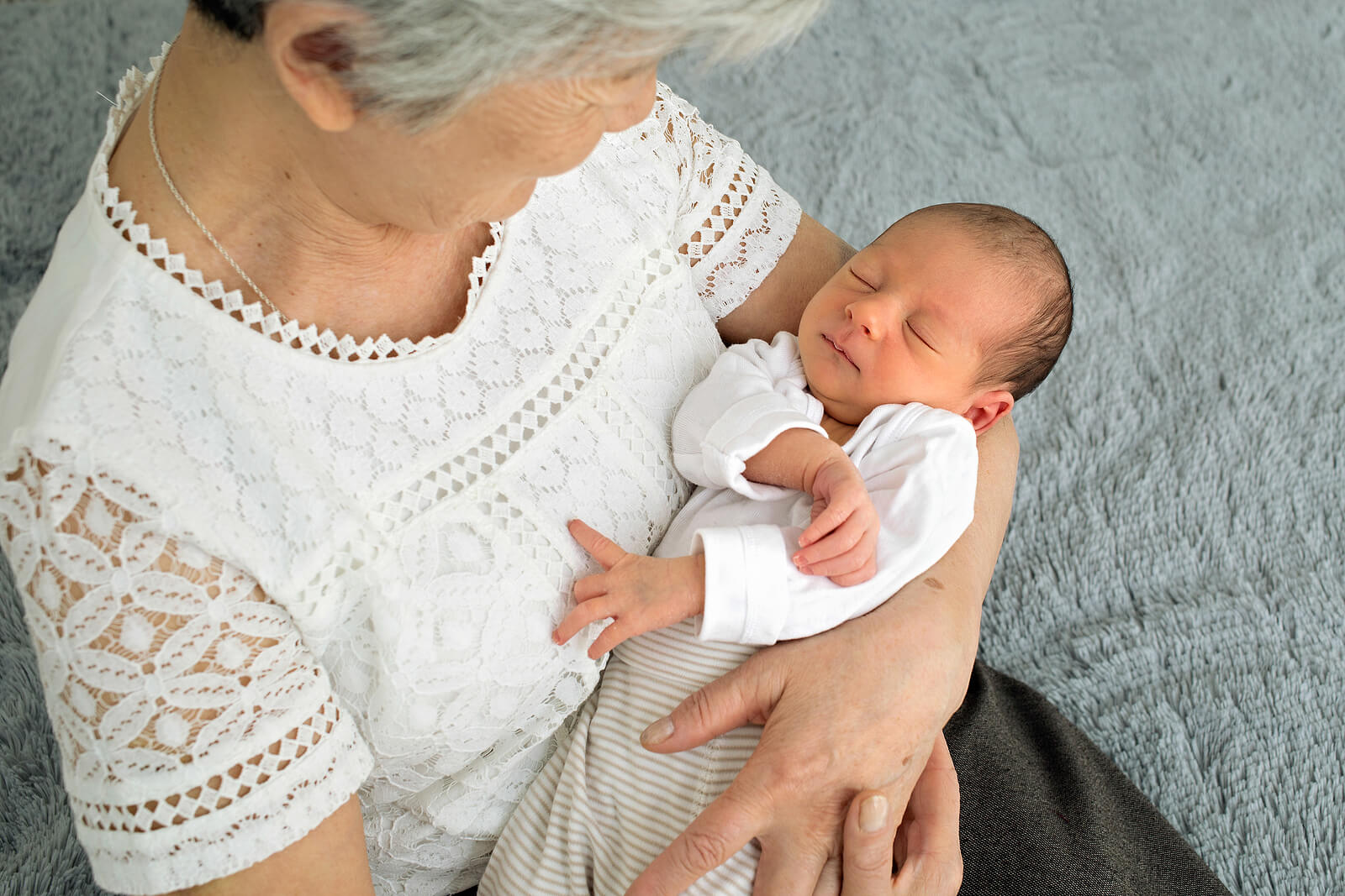 Abuela con su nieto recién nacido en brazos.