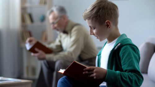 Abuelo y nieto leyendo libros de poesía.