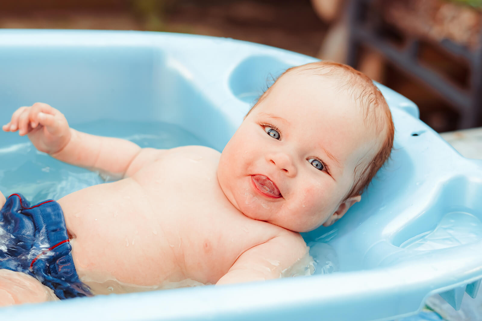 A baby lying in a baby bathtub.