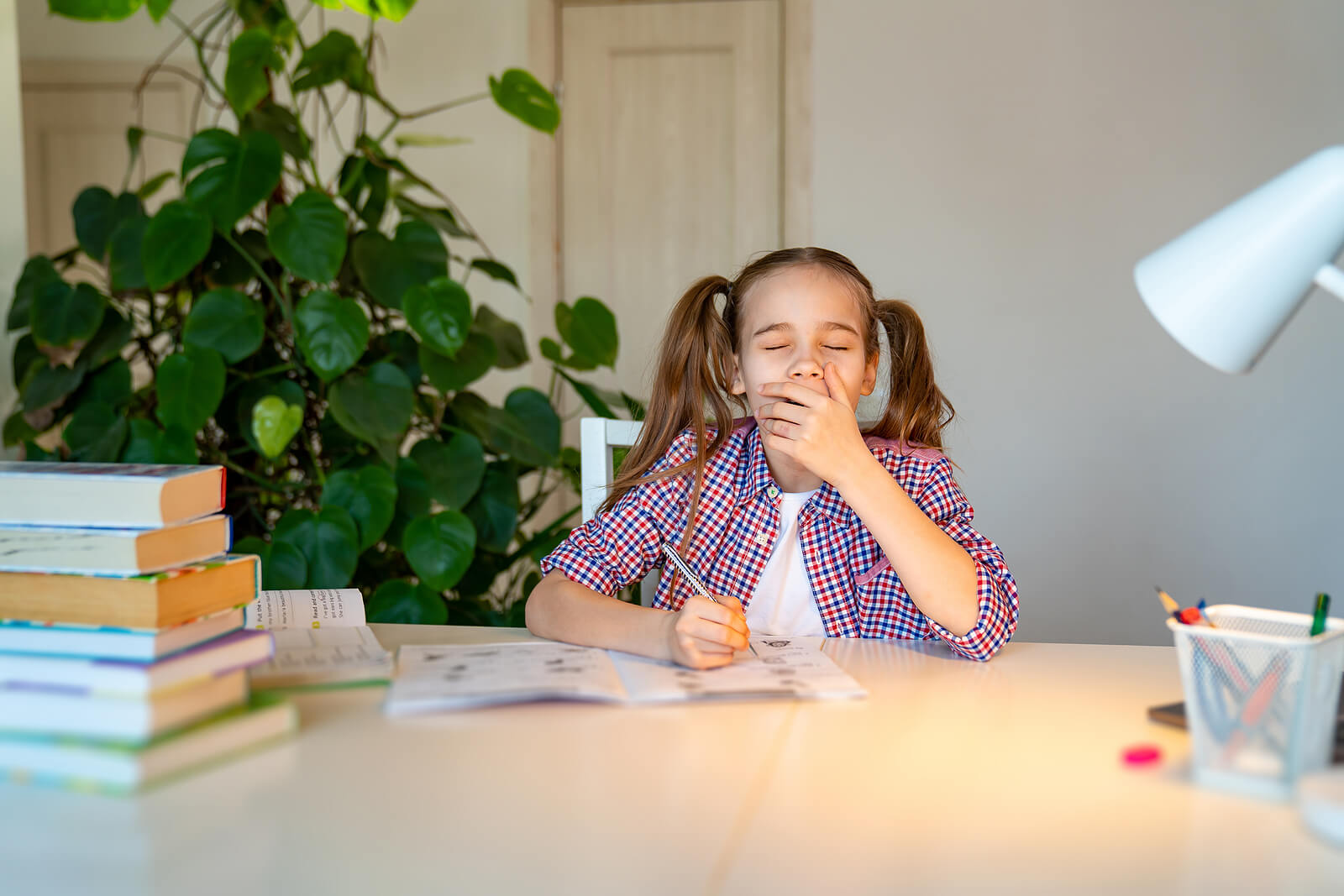 Chica adolescente estudiando muerta de sueño.