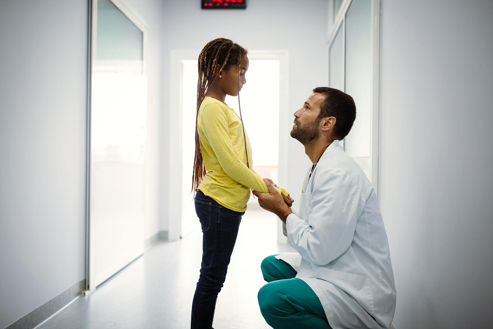 Doctor hablando con una niña para que mierda el miedo al médico.