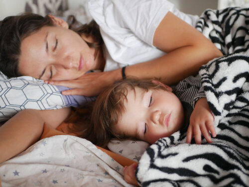 Madre e hijo durmiendo en la misma cama.