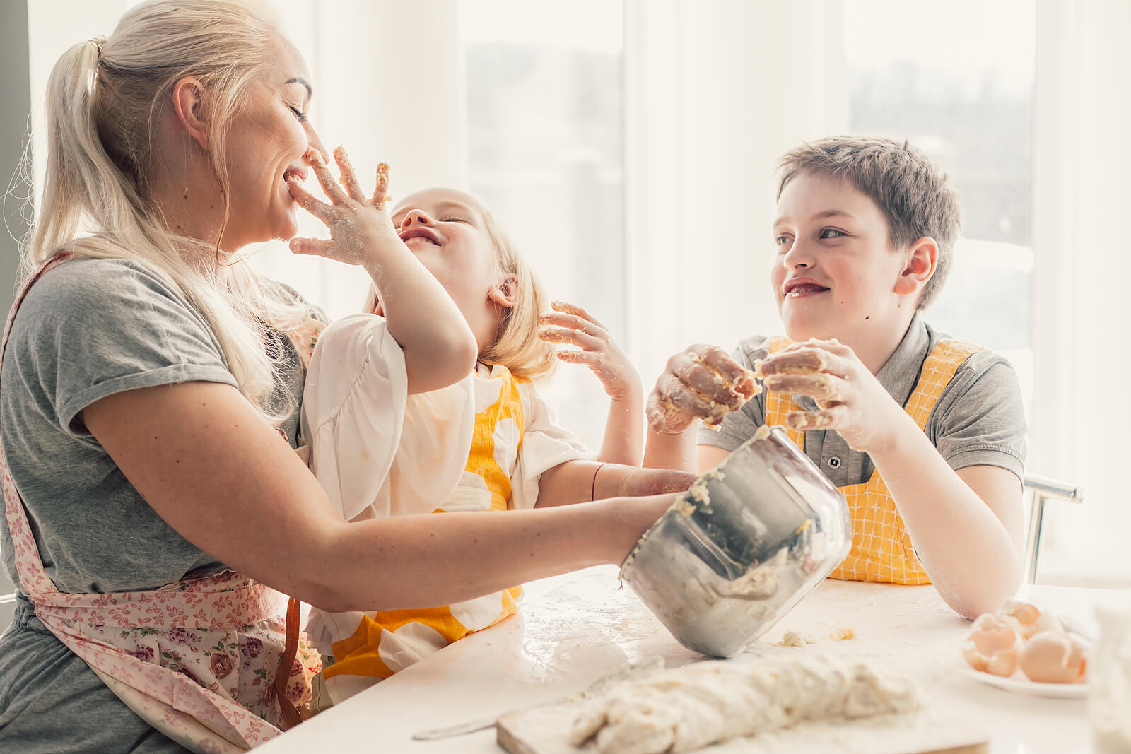 Madre con sus hijos haciendo actividades de cocina para niños.