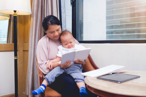 Mamá leyendo un libro de poesía infantil a su bebé.