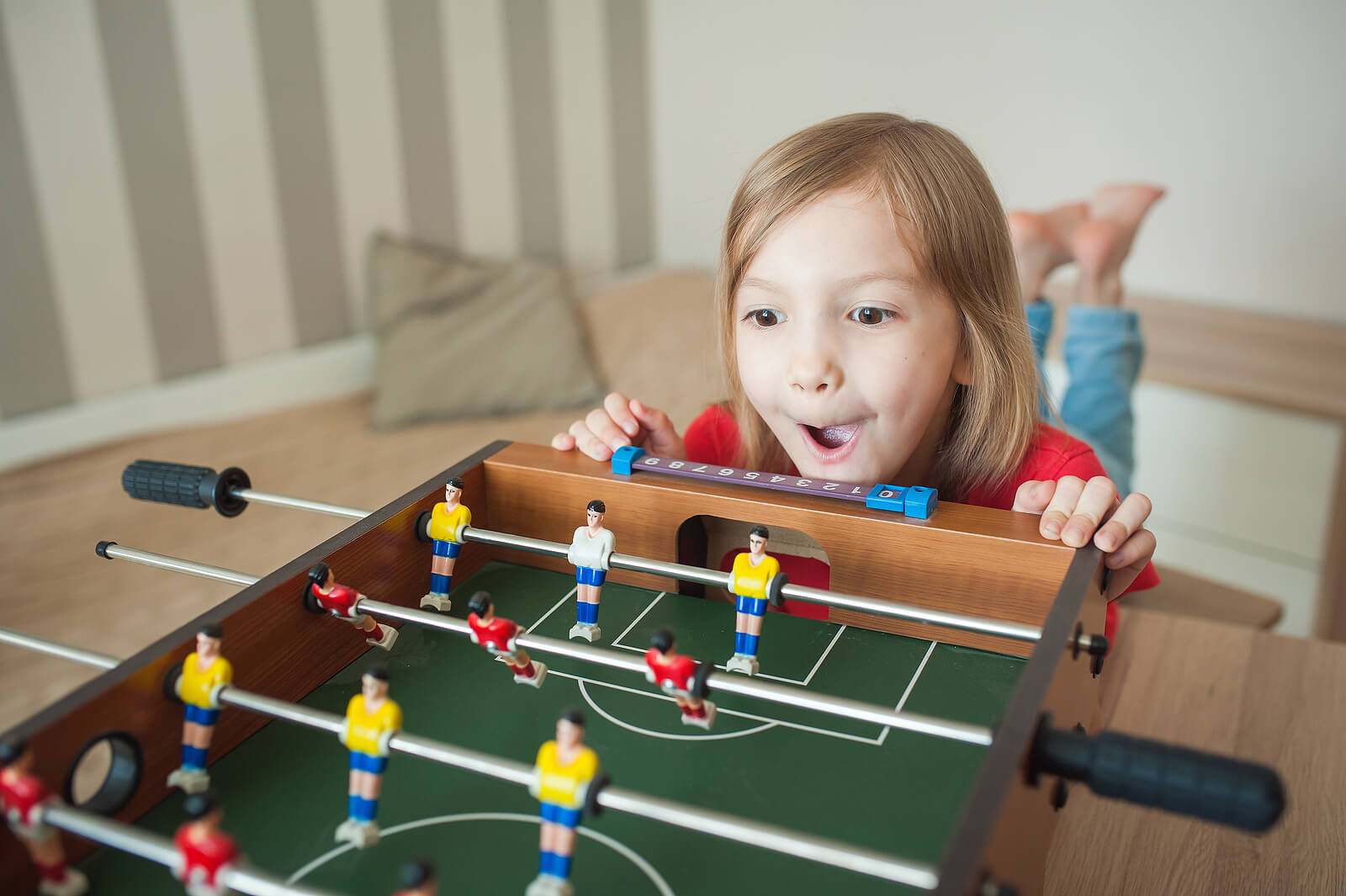 Niña impulsiva deseando jugar al futbolín.