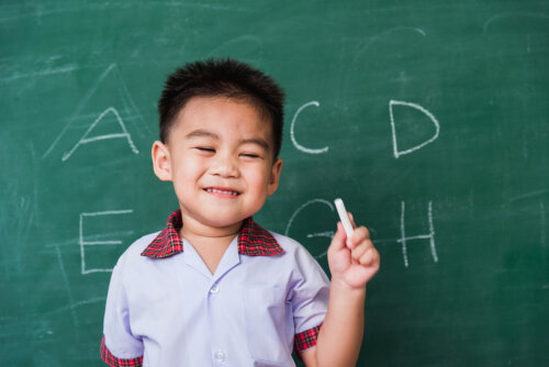 Niño aprendiendo a escribir en una pizarra.