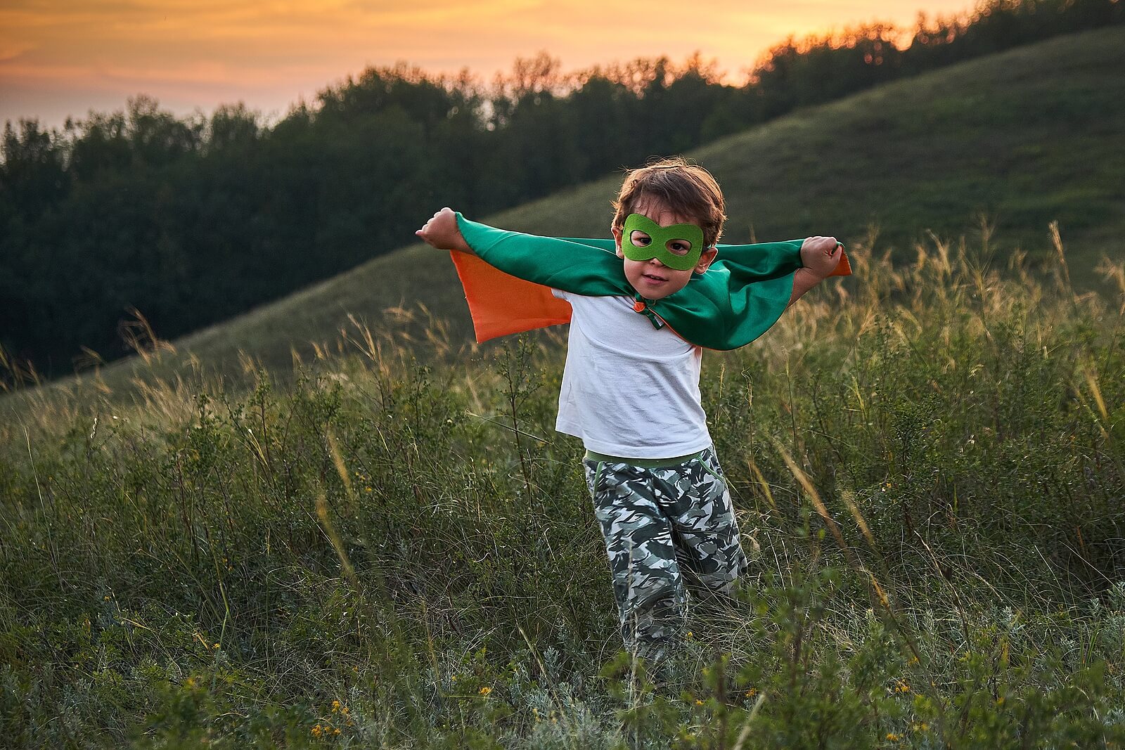 Niño disfrazado de superhéroe en el campo para desarrollar su imaginación y creatividad.