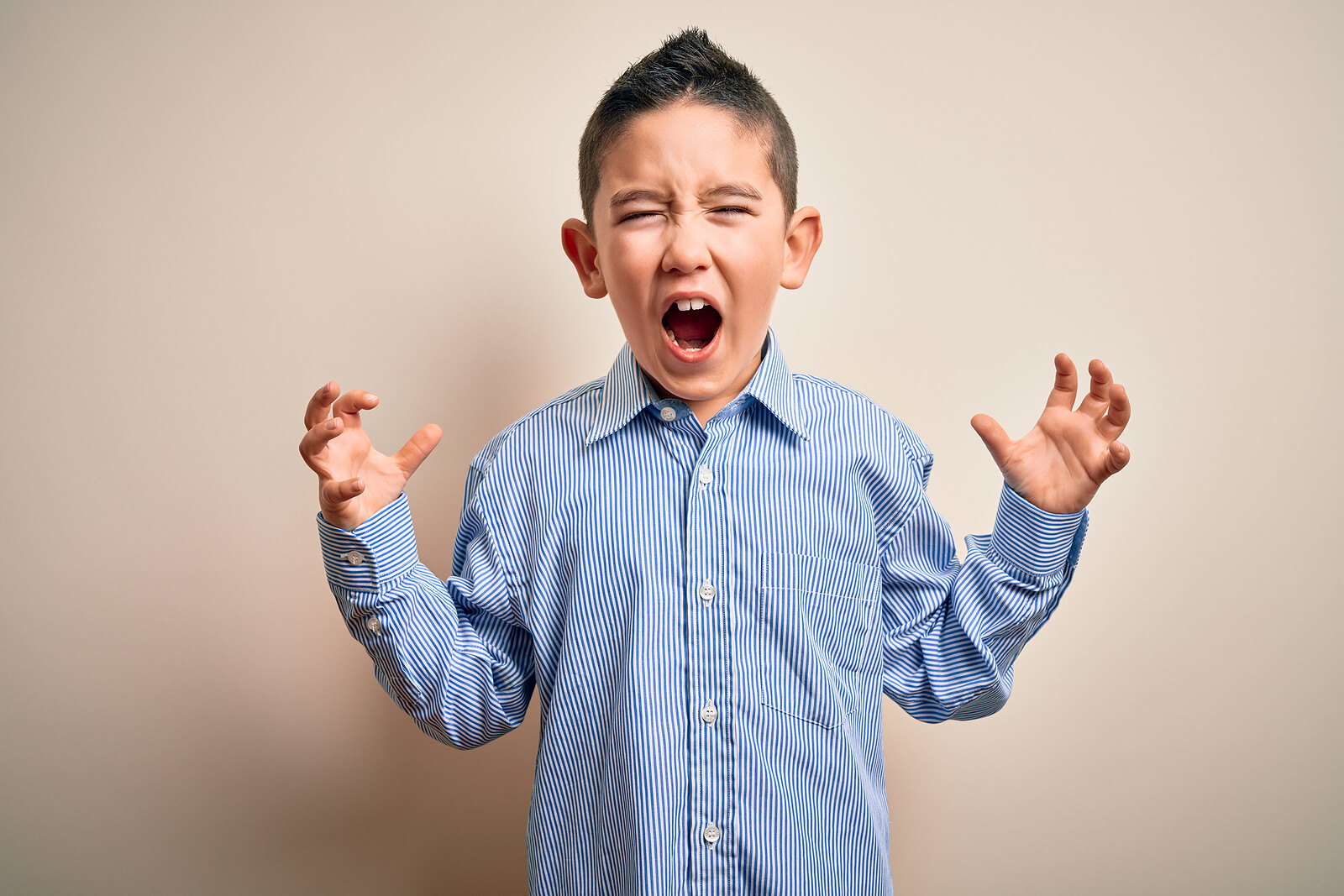 Niño gritando de ira porque no sabe cómo controlar su enfado.