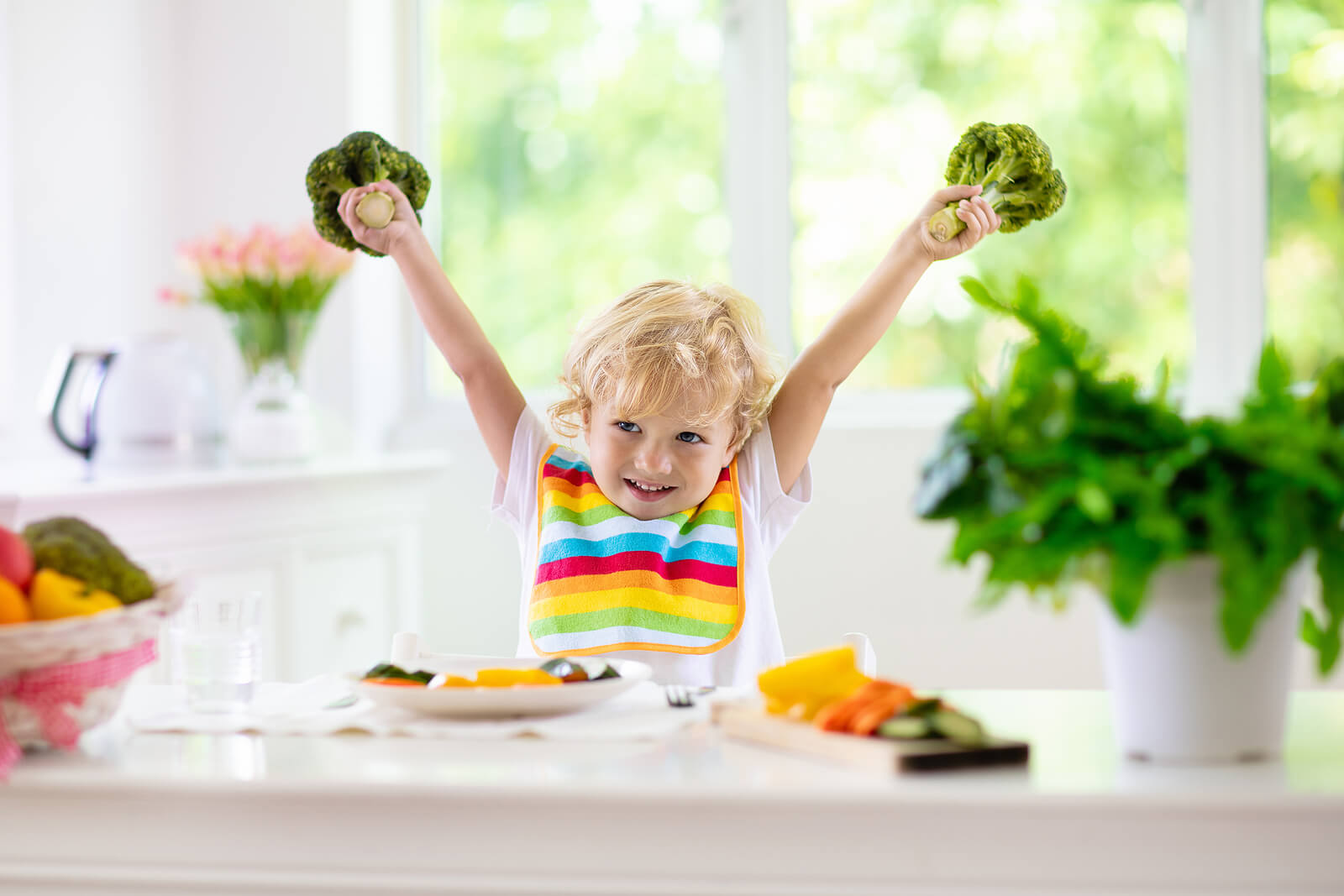 Niño feliz porque va a comer frutas y verduras.