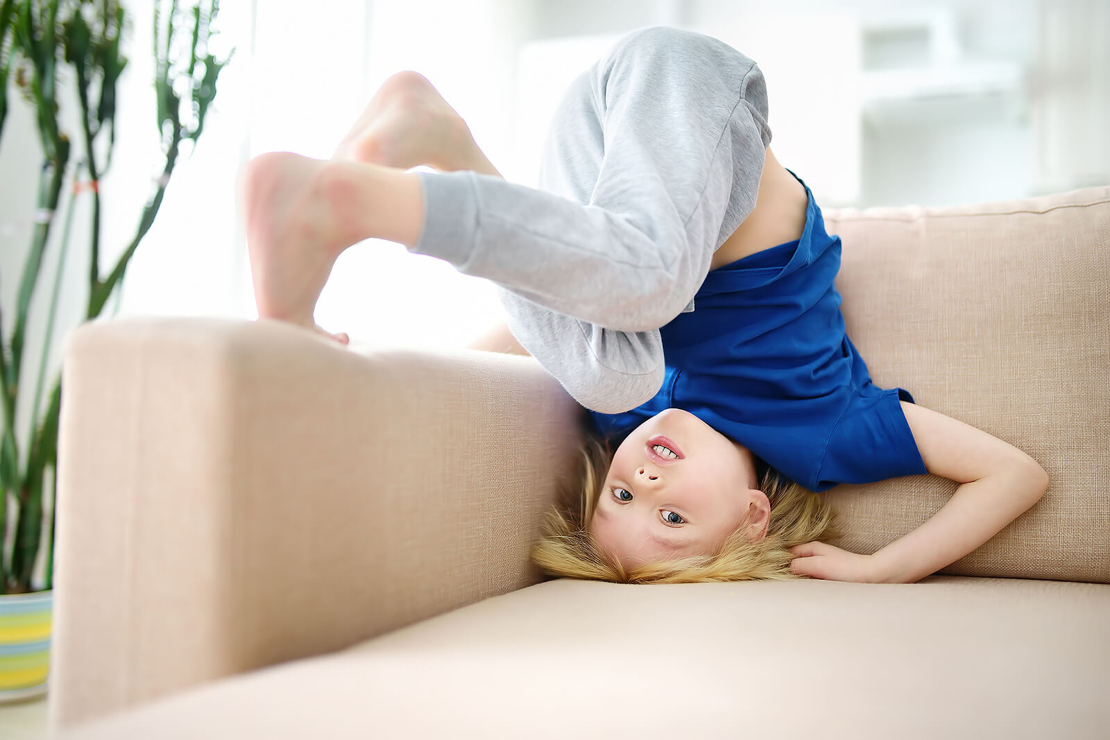 Niño haciendo la voltereta en el sofá porque forma parte de los niños impulsivos.