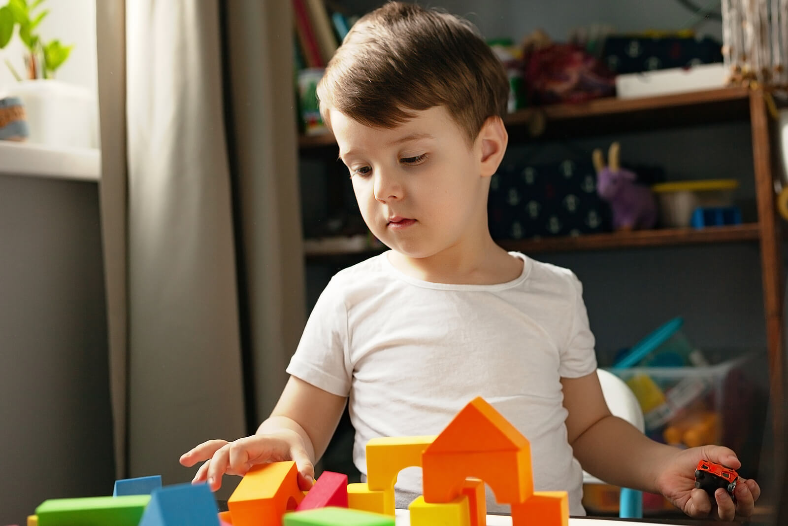 Niño jugando con los bloques de construcción pero sin querer recogerlos.