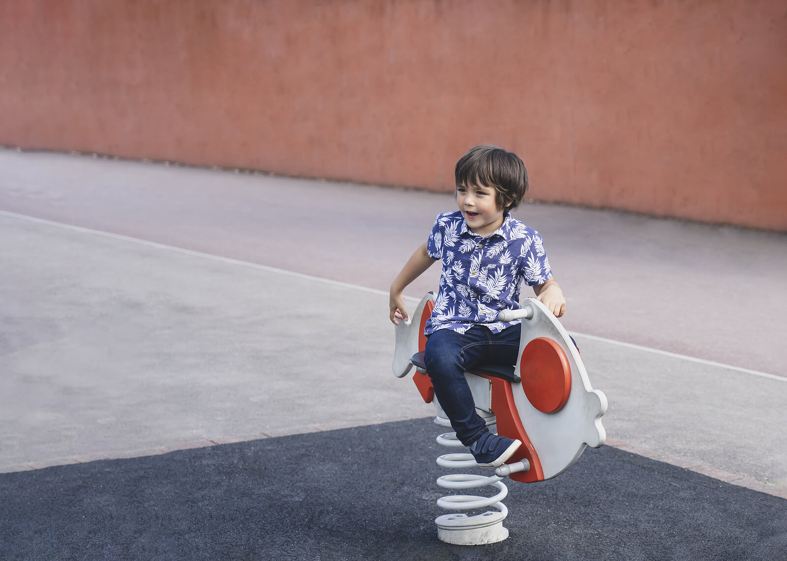 Niño jugando solo en un columpio del parque.