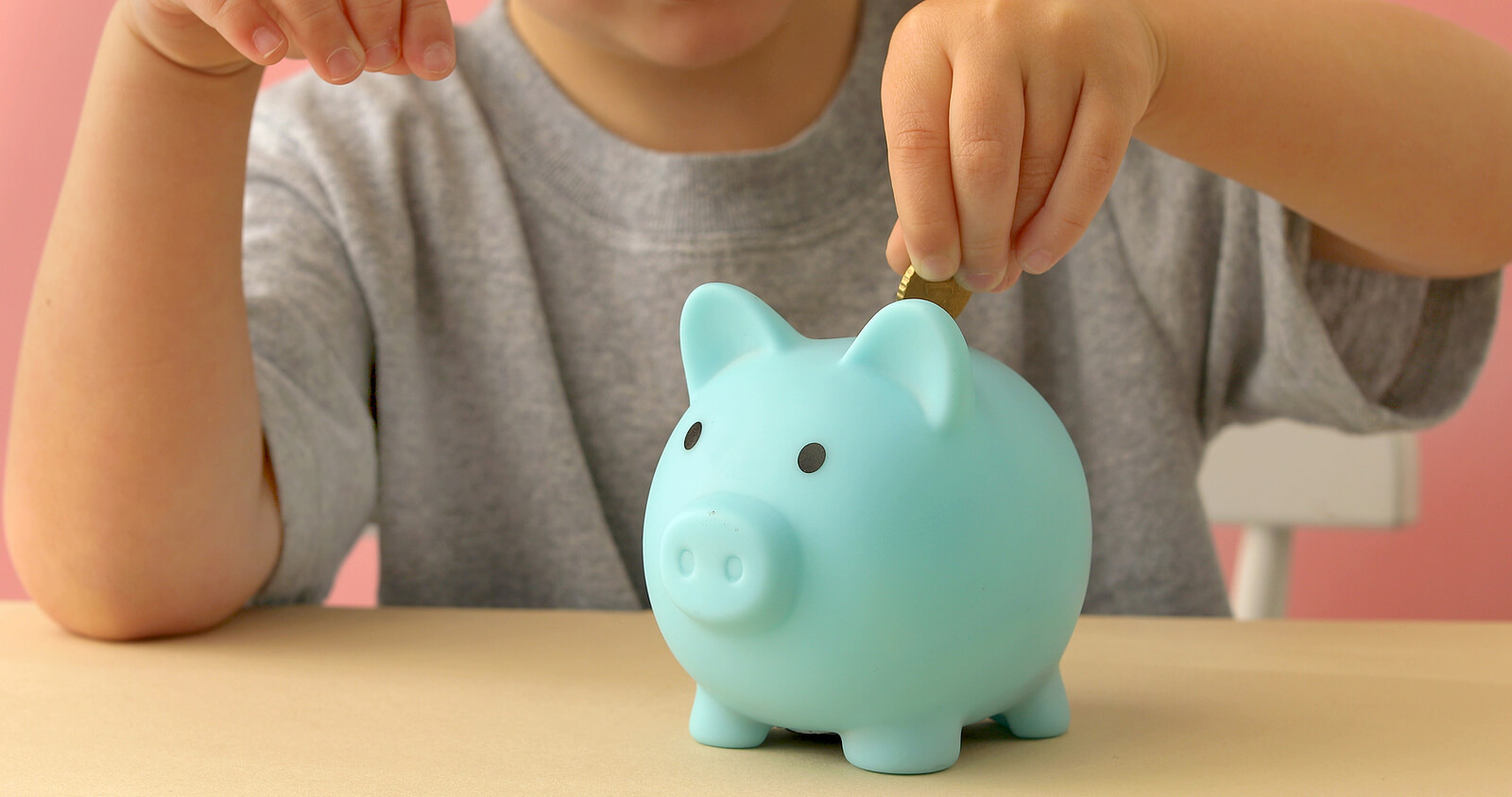 Niño metiendo dinero en una hucha.