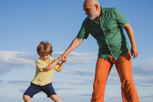 Niño tirando del brazo de su abuelo.