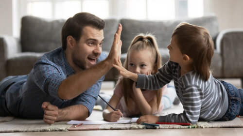 Padre chocando la mano con su hijo como parte de usar los elogios como premios y recompensas para niños.