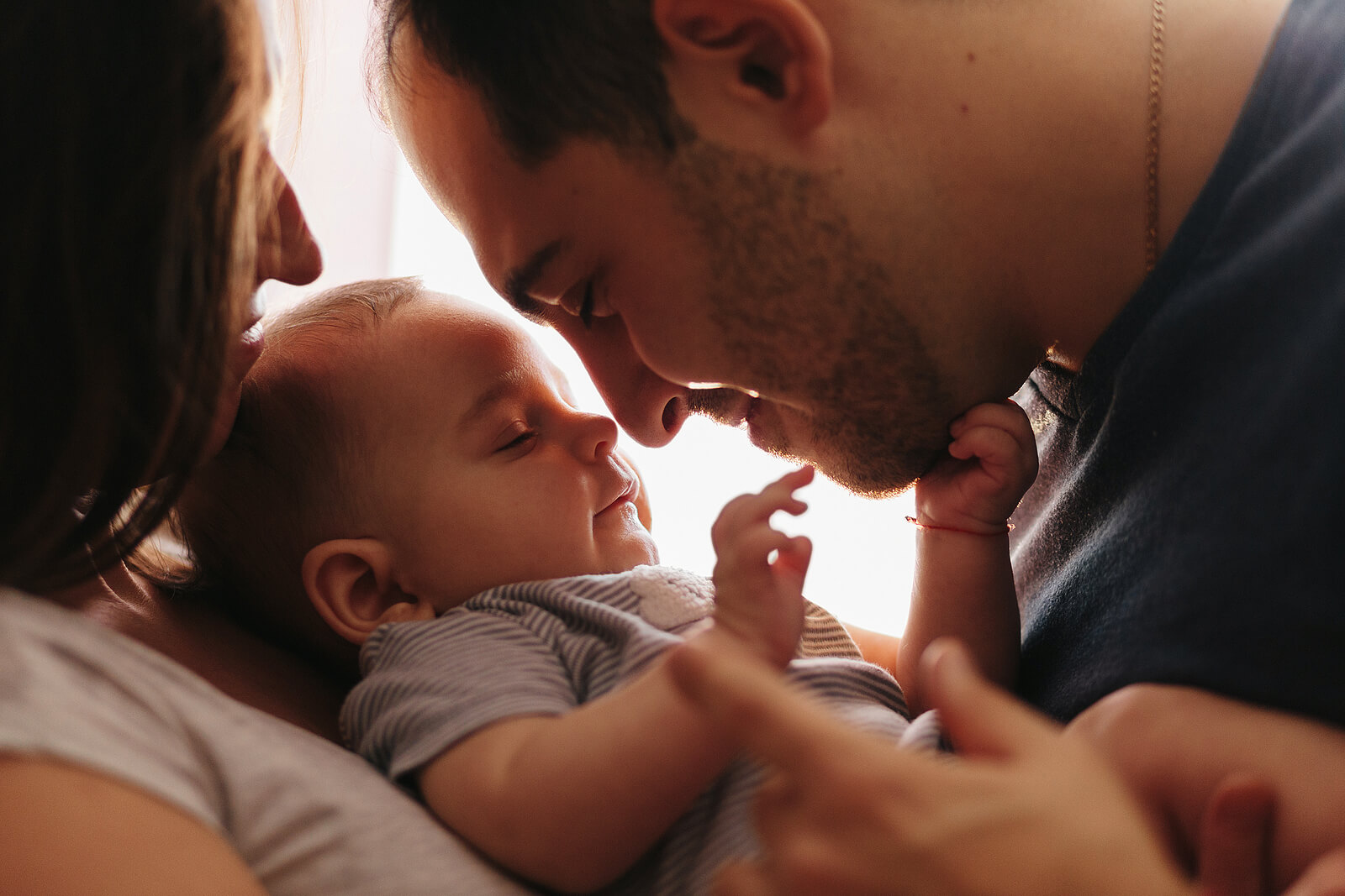 Padres abrazando a su bebé para crean un vínculo y conectar con él.
