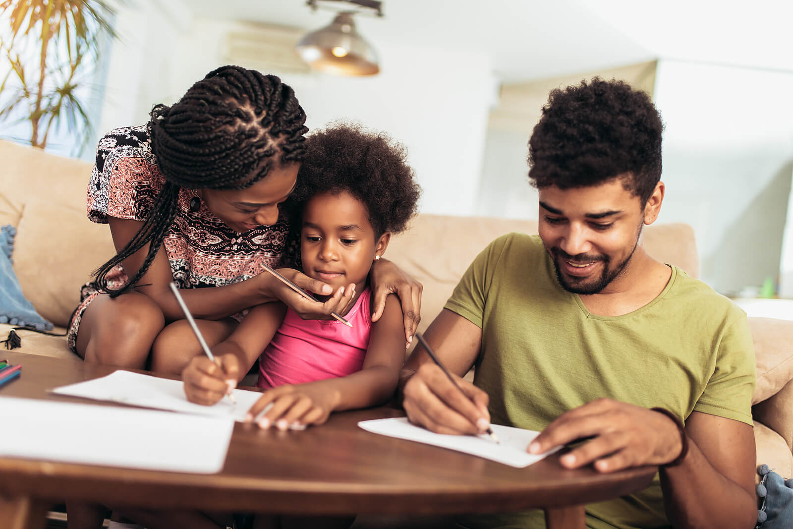 Parents helping their daughter with her homework.
