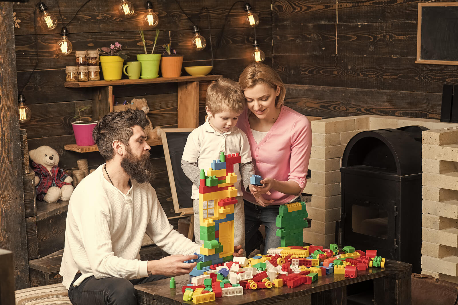 Padres jugando con su hijo con las piezas de construcción de LEGO Education.