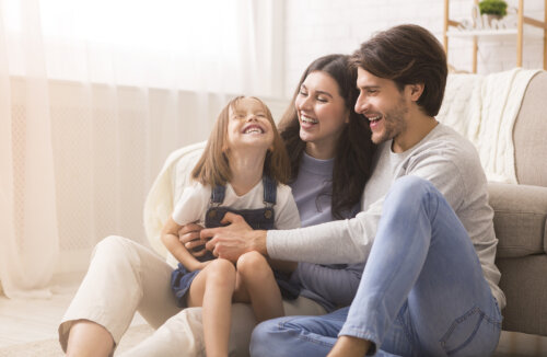 Padres haciéndole cosquillas a su hija.