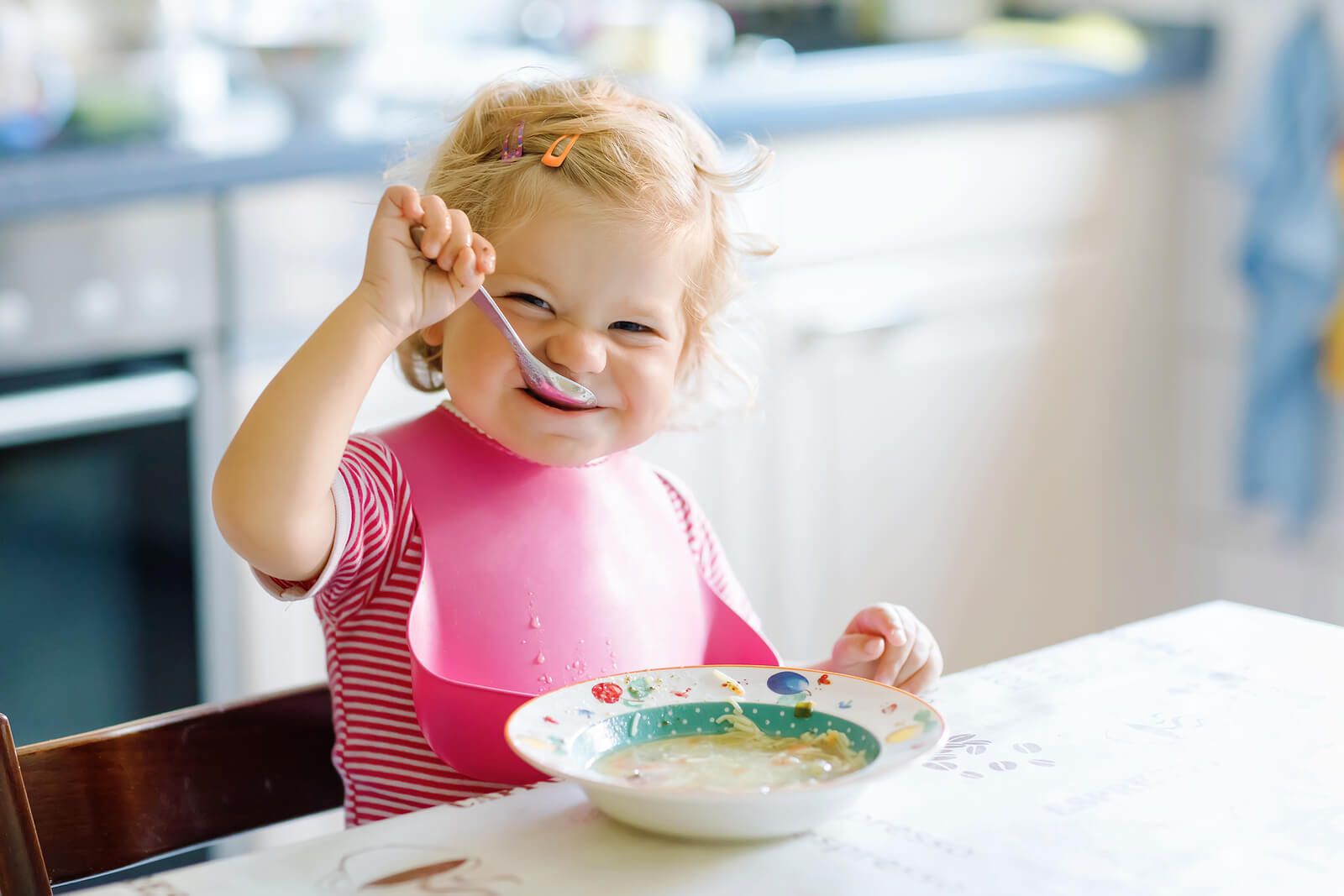 Bebé comiendo solo con cuchara une dieta con gluten.
