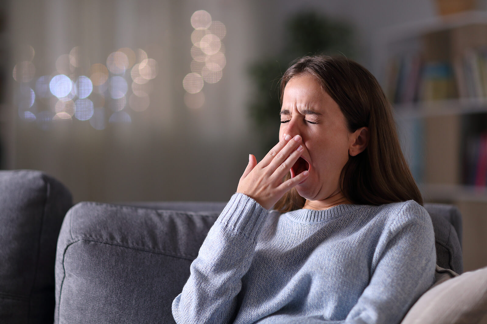 Chica adolescente bostezando debido a que sufre el síndrome de fatiga crónica.