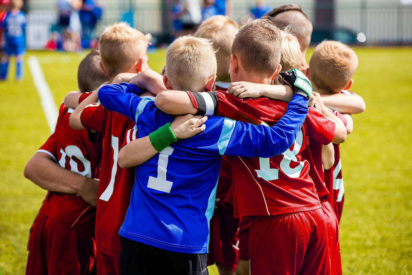 A boys soccer team in a huddle.