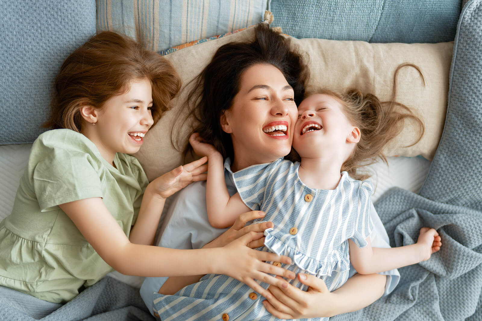 Madre disfrutando con sus hijas mientras se ríen.