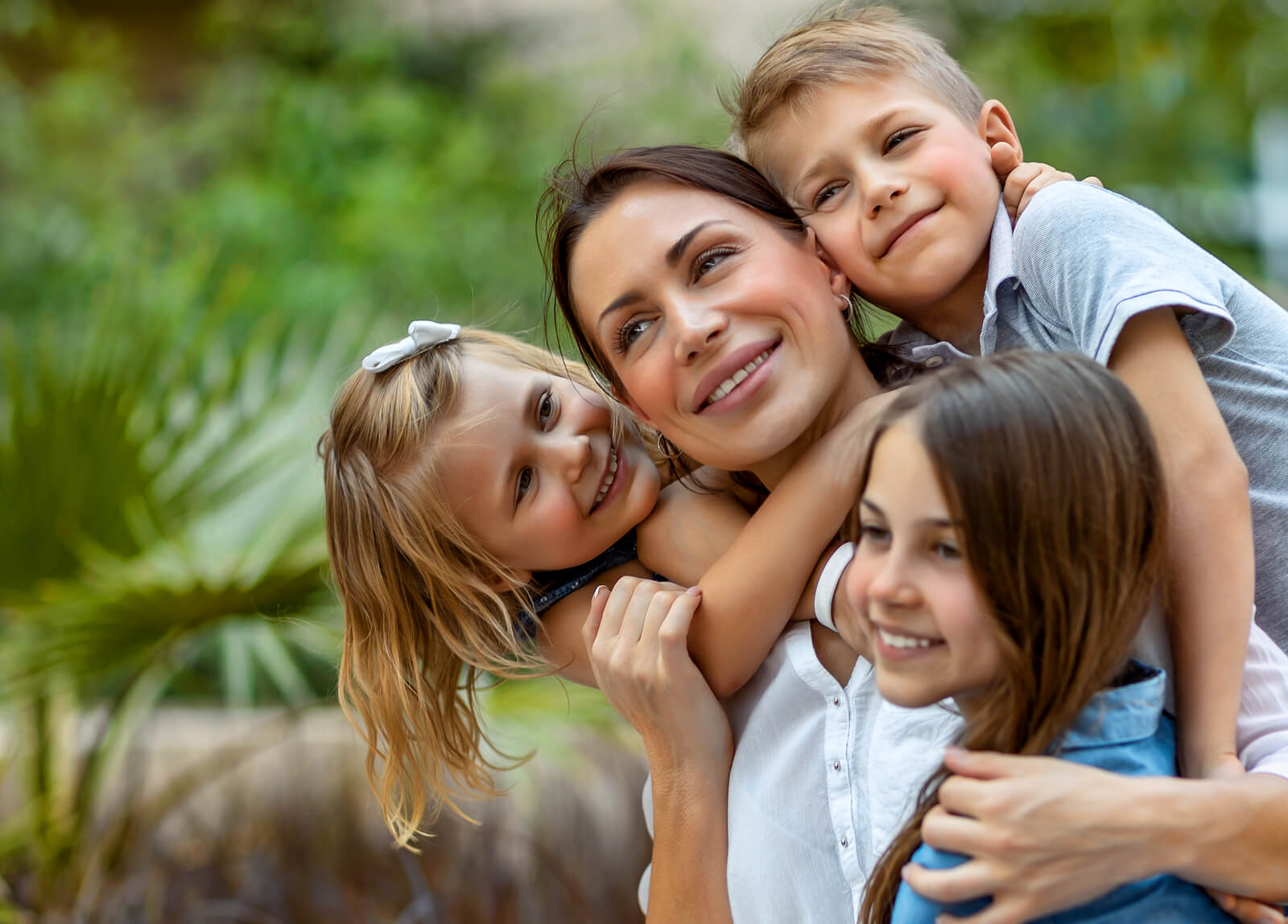 Madre feliz sintiendo el calor de sus hijos dentro del caos de la maternidad.