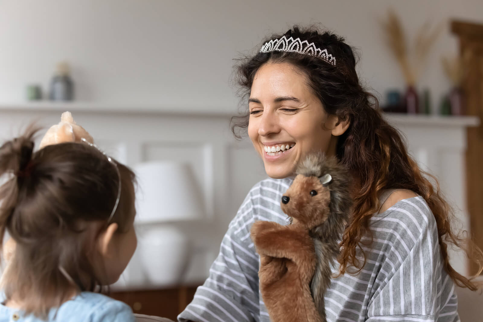 Madre e hija jugando con marionetas y disfrazadas de princesas.
